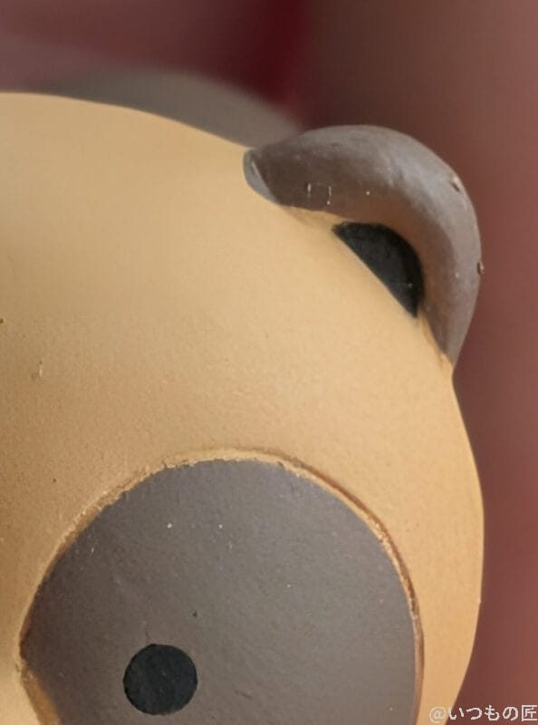 | モバイル比較レビュー.jp Google Pixel 10 カメラ 手のひらの上に置かれた狸のマスコット人形